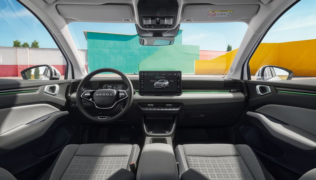 Škoda Epiq — kokpit z zieloną listwą ambientową, jasna tapicerka, ekran 13 cali