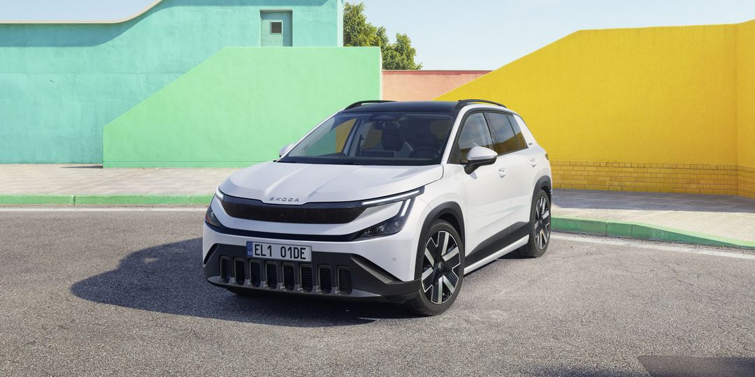 Škoda Epiq — przód i bok, biały SUV na tle kolorowych murów