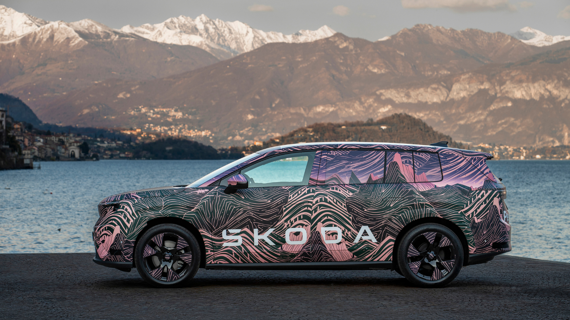 Škoda Peaq — profil boczny lewy, postój nad jeziorem, ośnieżone szczyty górskie w tle, kamuflaż topograficzny