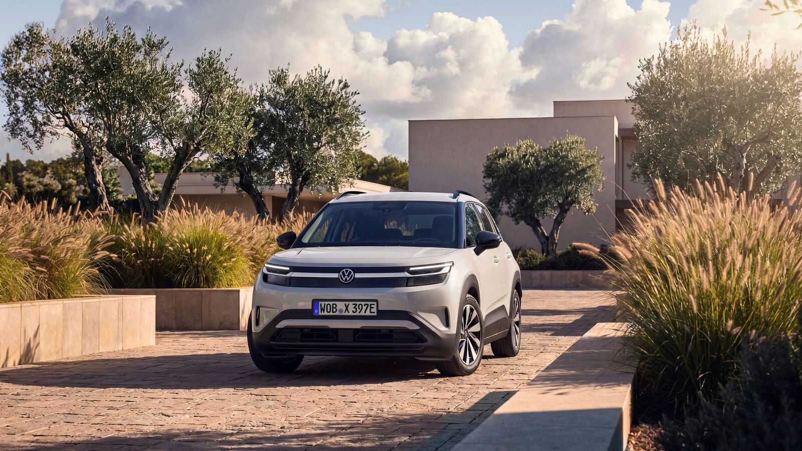 Volkswagen ID. Cross — przód, stojący na posesji z widokiem na dom i roślinność